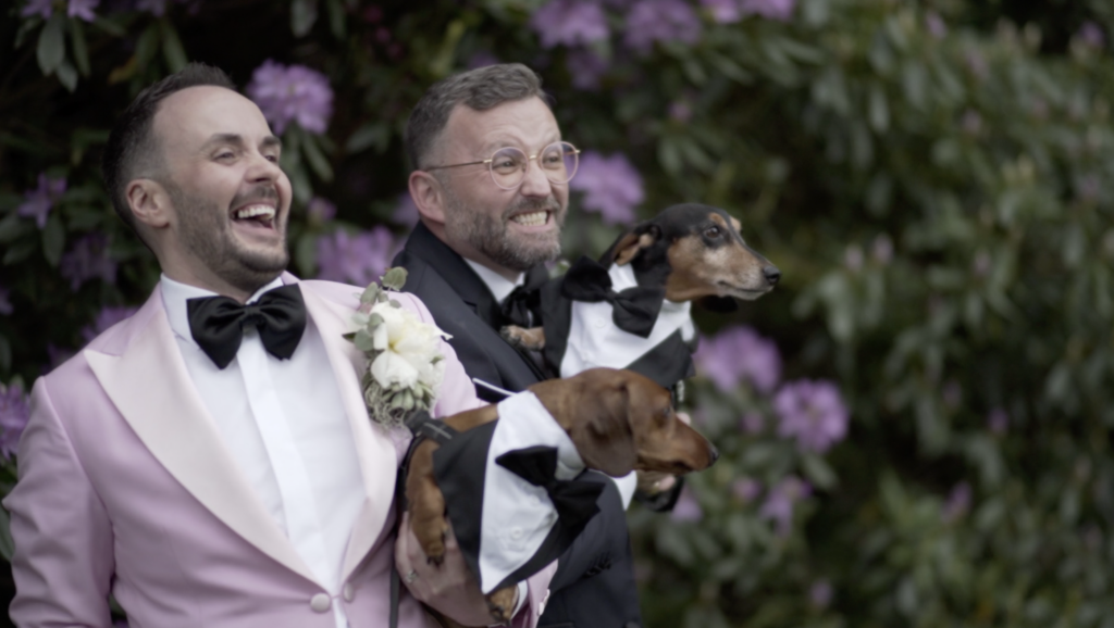 Grooms posing with sausage dogs